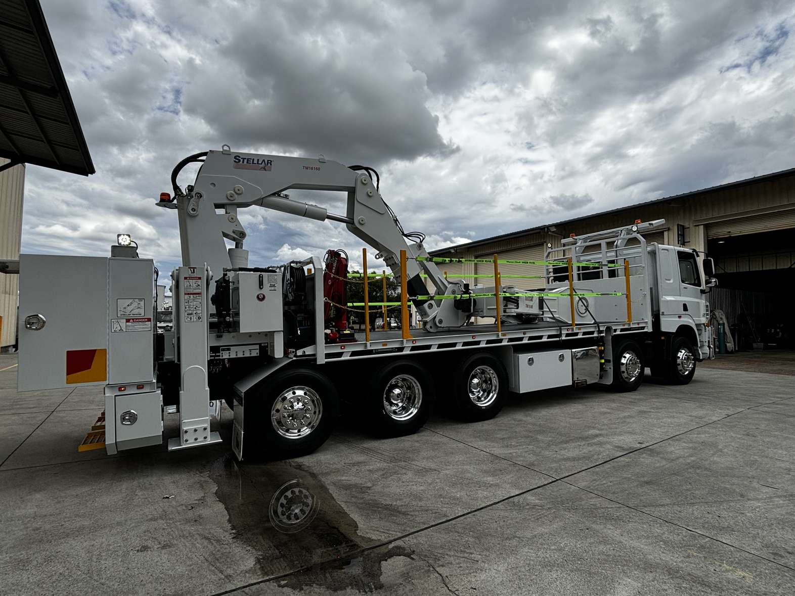 Side/back view of a truck with tyre handler crane and flatbed tray